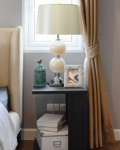 Декоративная настольная лампа на черном деревянном столе в интерьере спальни — стоковое фото