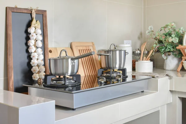 Panela de aço inoxidável no fogão a gás com utensílio na cozinha moderna — Fotografia de Stock