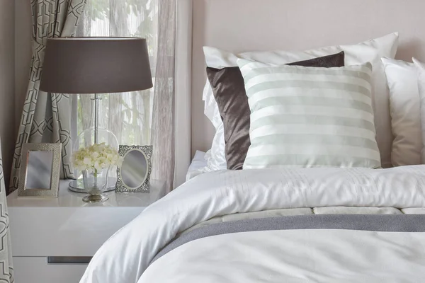 Современный интерьер спальни с полосатой подушкой на кровати и прикроватной лампой — стоковое фото