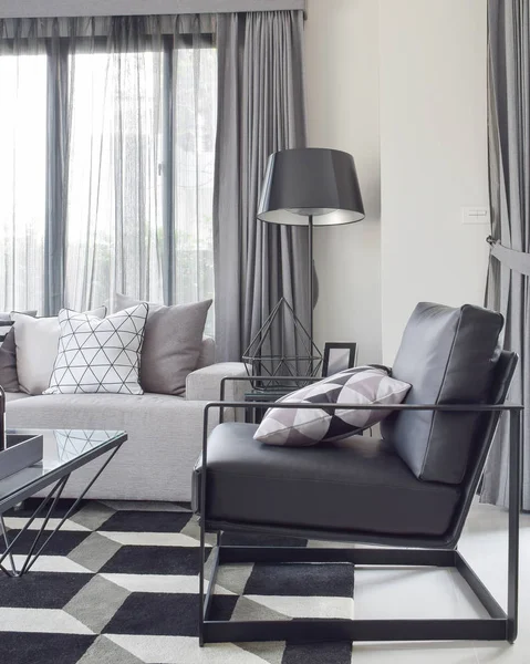 Schwarzer Sessel mit geomatrischem Teppich in moderner Wohnecke — Stockfoto