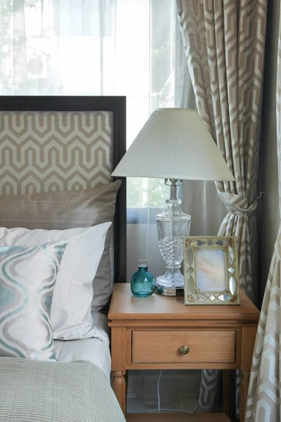 Interior del dormitorio de lujo con almohadas estampadas verdes en la cama y lámpara de mesa decorativa . — Foto de Stock