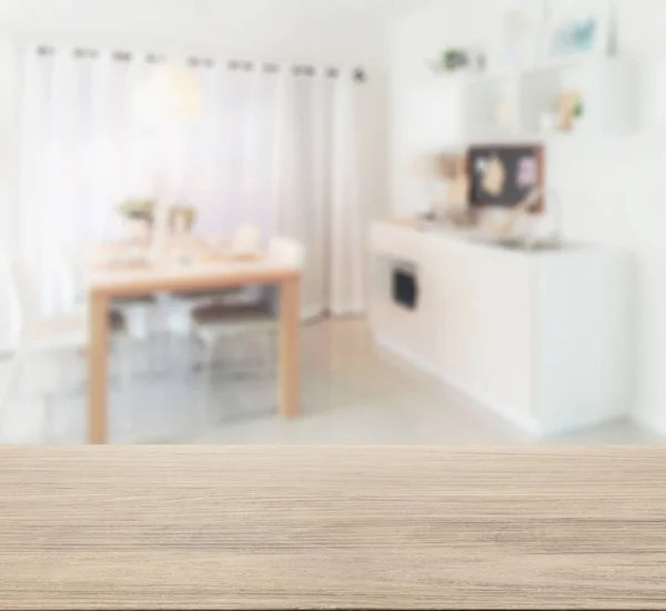 wooden table top with blur of wooden dining table next to pantry in modern kitchen