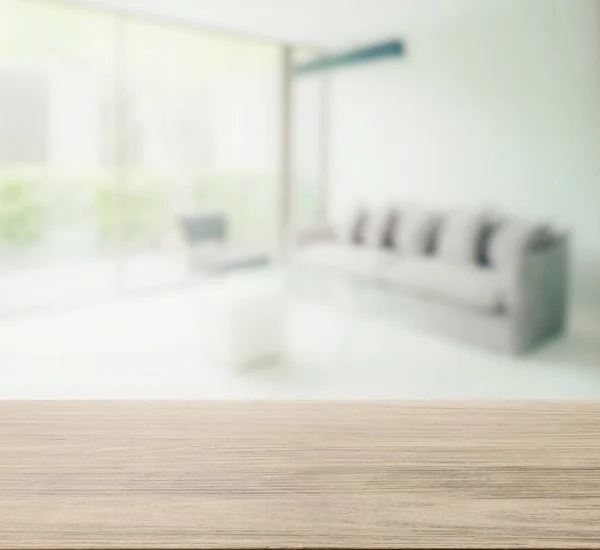 Wooden table top with blur of modern living room interior — Stock Photo, Image