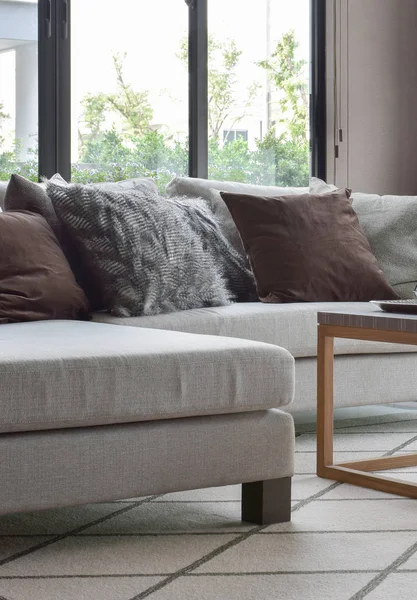 Almohadas marrones y grises en sofá beige en la sala de estar moderna — Foto de Stock
