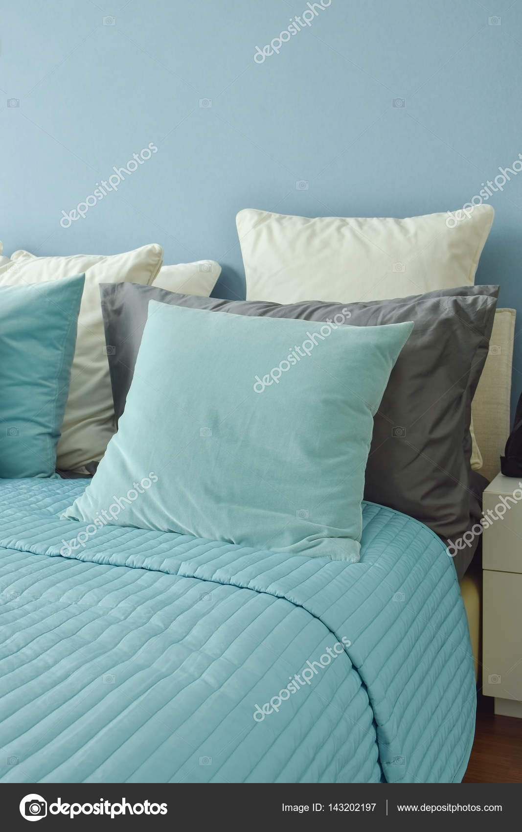 Blue Light Blue And Beige Pillows On Bed In Blue Wall