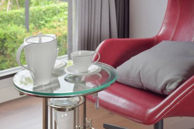 Kırmızı sandalye oturma odasında ile cam üst tabloda çay seti