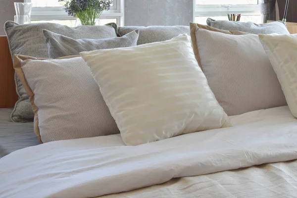 Stylish bedroom interior design with white striped pillows on bed — Stock Photo, Image