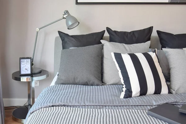 Elegante dormitorio de diseño interior con almohadas con dibujos negros en la cama y lámpara de mesa decorativa . —  Fotos de Stock