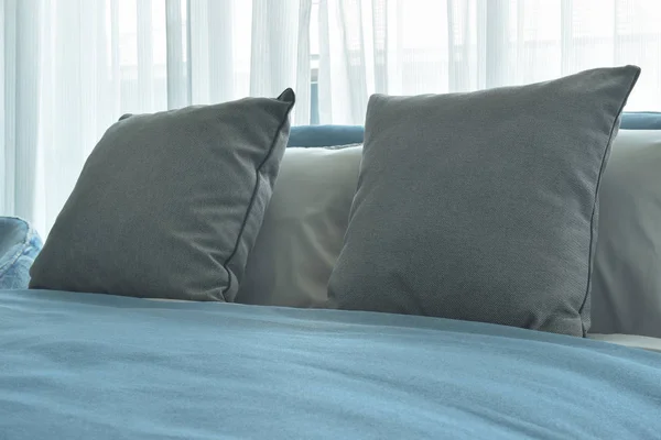 Χρώμα γκρι μαξιλάρια στο κρεβάτι με μπλε κουβέρτα σε μοντέρνα κρεβατοκάμαρα — Φωτογραφία Αρχείου