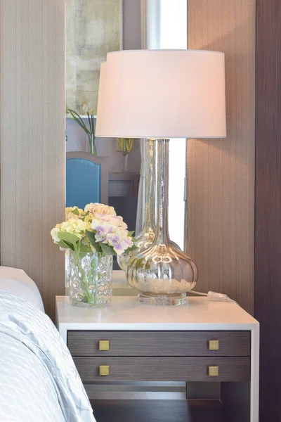 Класичний інтер'єр спальні з подушками і світильником на тумбочці — стокове фото