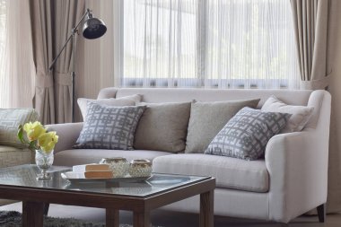 Sıcak oturma odasında bej kanepe üzerinde ayarlama deseni yastık