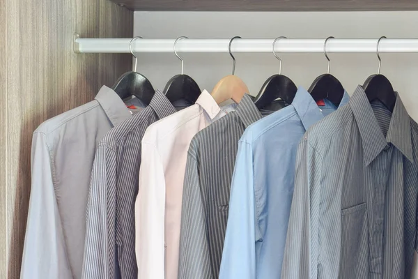 Row of colorful shirts hanging in wardrobe — Stock Photo, Image