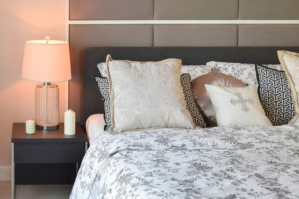 Роскошный интерьер спальни с цветочным узором подушки и декоративные настольные лампы — стоковое фото