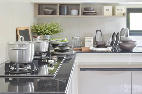 Panelas de aço inoxidável e cerâmica configuração do artigo no balcão na cozinha — Fotografia de Stock