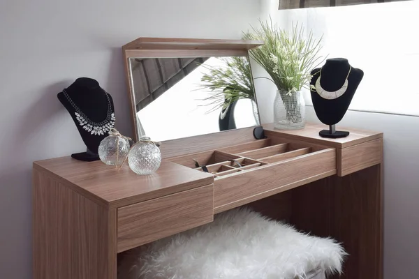 Vackra halsband på trä toalettbord och träpall — Stockfoto