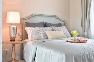 Dekoratif pirinç tepsi yatakta gözlük, kitap ve güneş gözlüklü