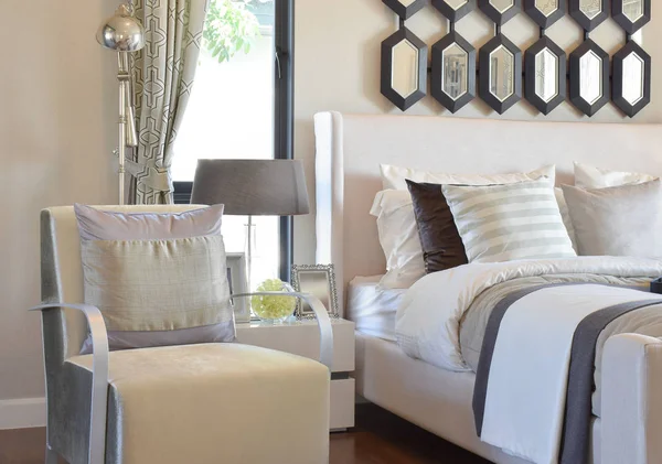 アームチェアとベッドサイド テーブルのランプを自宅に灰色の枕でモダンな寝室のインテリア — ストック写真