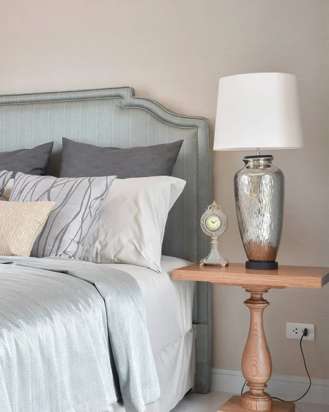Роскошный интерьер спальни с декоративной настольной лампой и будильником на тумбочке — стоковое фото