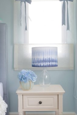 Çiçek kavanoz ve okuma lambası başucundaki ışık mavi iç yatak odasında
