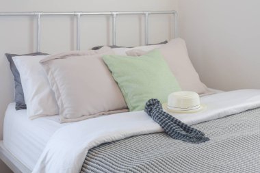 Pastel renkli yastıklar battaniyeyle şerit eşarp ve beyaz şapka ayarda