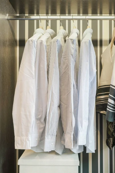 Fila de camisas brancas penduradas no guarda-roupa de fundo estilo retro — Fotografia de Stock