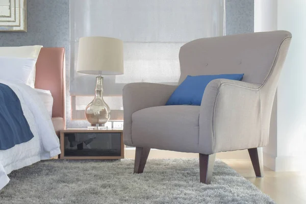 Кресло в стиле ретро с подушкой рядом с кроватью в современной интерьерной спальне — стоковое фото