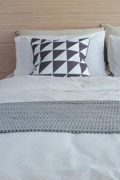 積層の木製のヘッドボードとベッドの上の黒と白の設定でグラフィック パターン枕 — ストック写真
