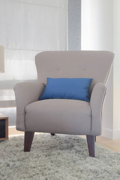 Gray color retro style armchair with blue pillow in living room