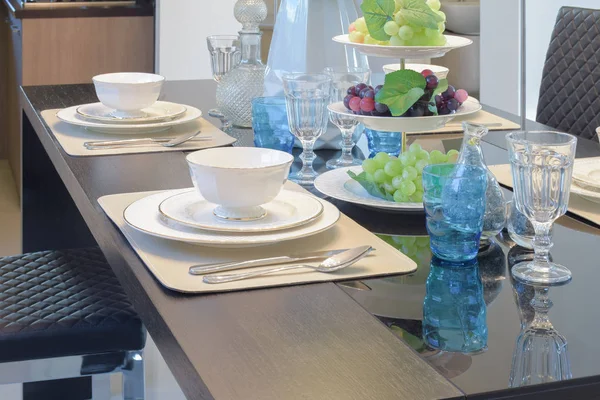 Ajuste Chinaware en mesa de comedor con cristal azul claro y frutas — Foto de Stock