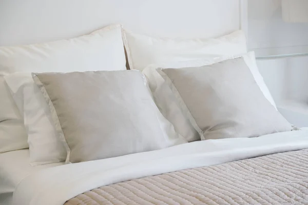 Světle šedý polštář nastavení na posteli v nice atmosféra ložnici moderním interiérem ve stylu — Stock fotografie