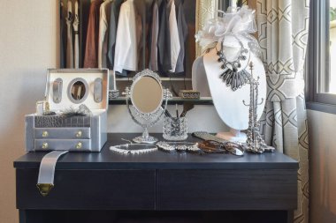 siyah bir tuvalet Masası üzerinde tablo ayna, güneş gözlüğü, takı ve makyaj fırçaları