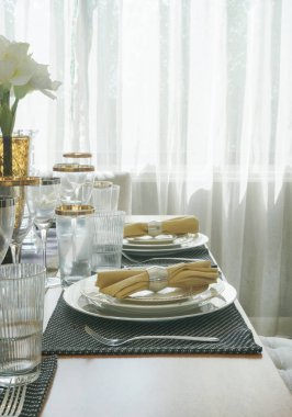 Elegance tarzı yemek masası ile altın trim Züccaciye ve tablo ortasına beyaz çiçek