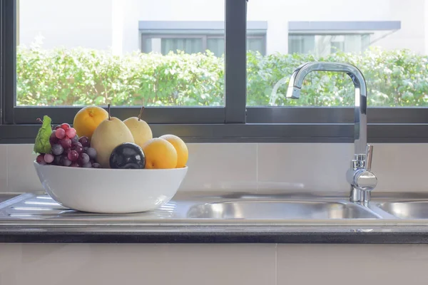 Frutas em uma tigela ao lado de afundar na cozinha — Fotografia de Stock