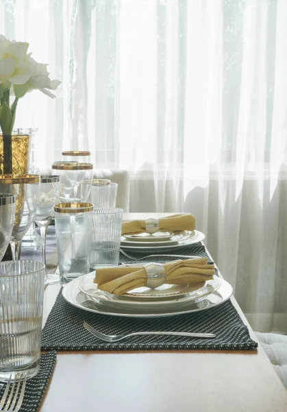 Elegancia stílusú étkező asztal arany trim üvegeszközök és az asztal közepén, a fehér virág — Stock Fotó