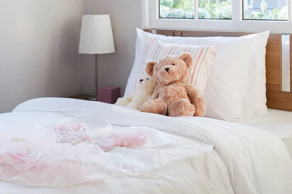 Dormitorio blanco decorativo con almohadas y muñecas en la cama —  Fotos de Stock