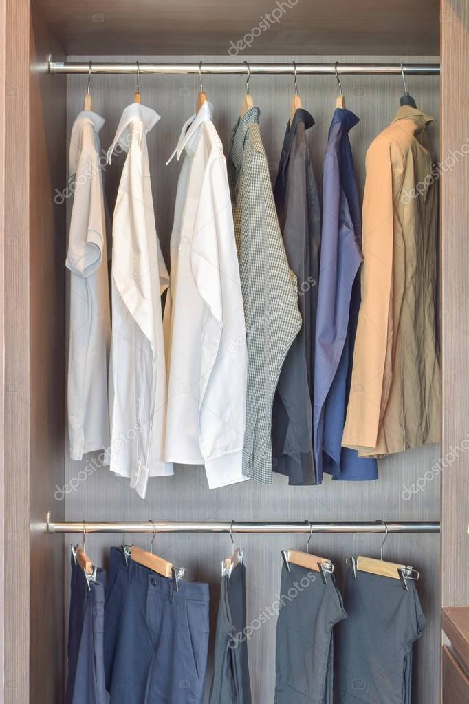 Klassische Farbe Hemden sind in offenen hölzernen Kleiderschrank hängen. — Stockfoto © WorldWide