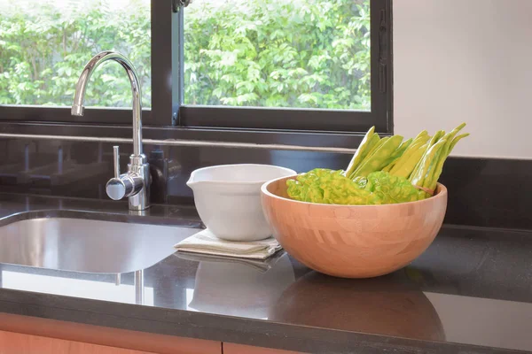 Lavatório de cozinha com uma tigela de legumes na cozinha — Fotografia de Stock