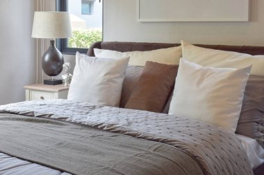 Beyaz ve kahverengi yastık yatak ve dekoratif masa lambası modern yatak odası iç