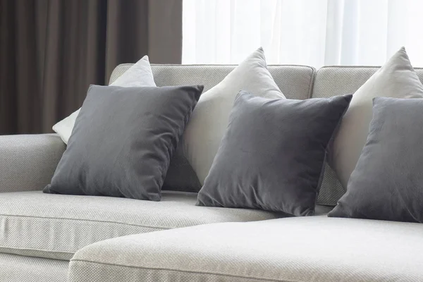 Almohadas blancas y grises colocadas en sofá beige en la sala de estar — Foto de Stock