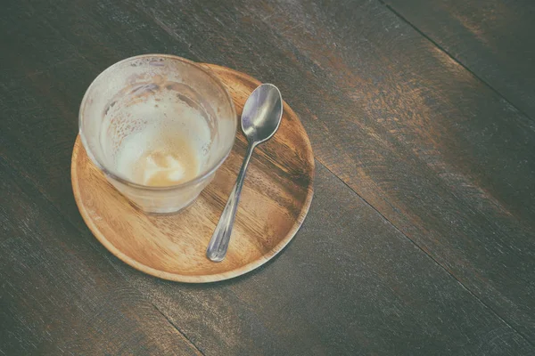 Порожня чашка кави з ложкою та дерев'яною тарілкою на столі — стокове фото