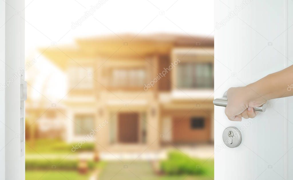 man hand opening white door to modern home exterior as background