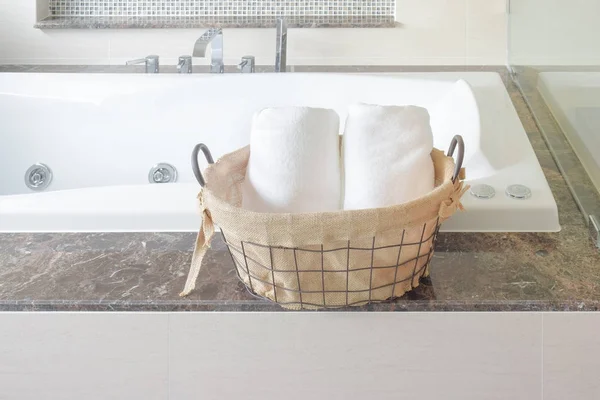 Handduk i korg naxt till badkar i badrummet — Stockfoto