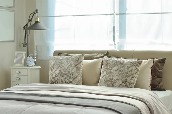 Роскошная спальня с лампой и будильником на деревянном столе дома — стоковое фото