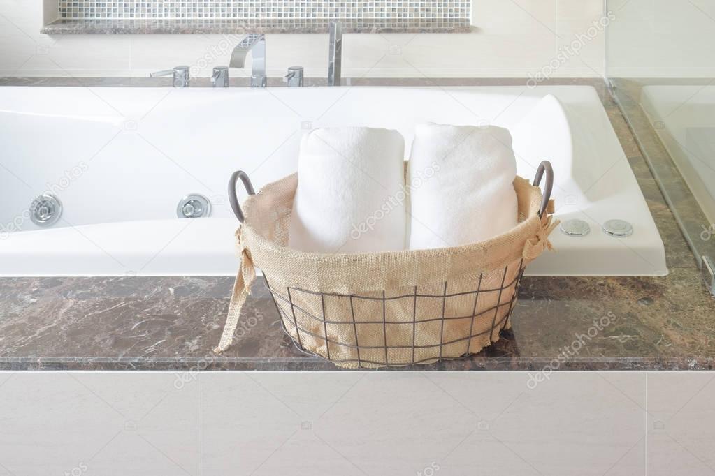 Towel in basket naxt to bathtub in the bathroom