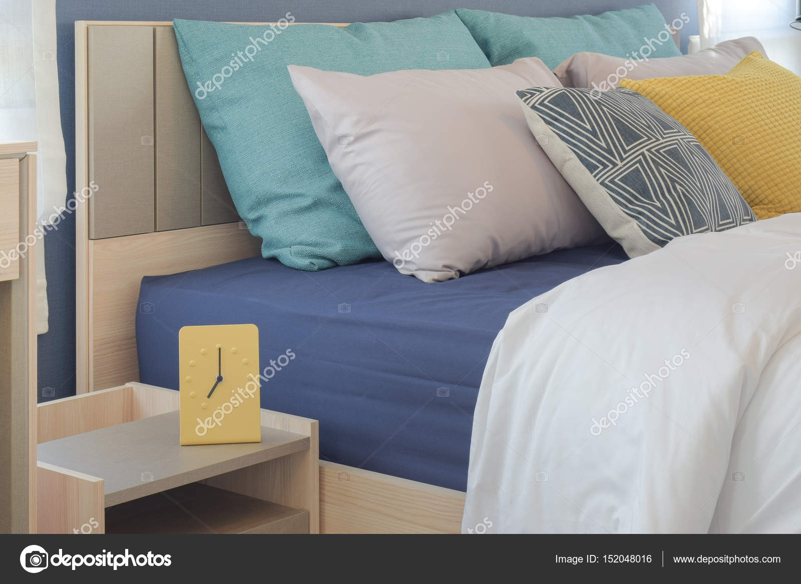 Yatakta sarı ve yeşil yastık ayarıyla modern tarzı sarı