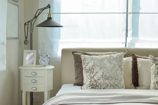 Dormitorio de lujo con lámpara y reloj despertador en la mesa de madera en casa —  Fotos de Stock