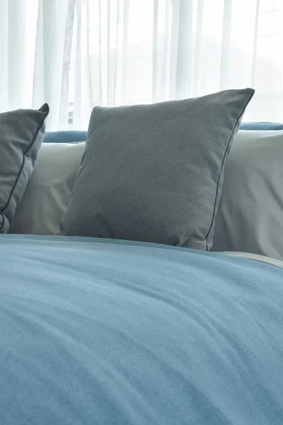 Χρώμα γκρι μαξιλάρια στο κρεβάτι με μπλε κουβέρτα σε μοντέρνα κρεβατοκάμαρα — Φωτογραφία Αρχείου