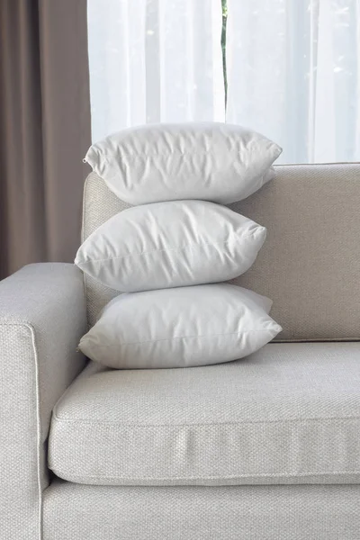Укладання білих подушок у кутку дивана у вітальні — стокове фото
