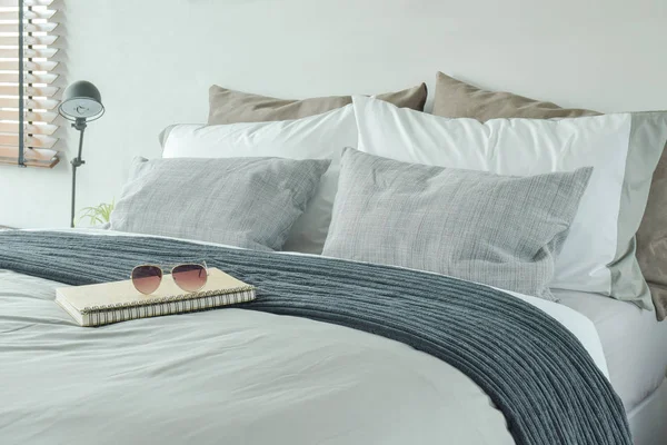 Notatnik i okulary na łóżku z poduszkami — Zdjęcie stockowe