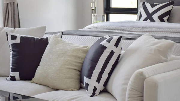 Travesseiro impresso gráfico preto e branco no sofá branco ao lado da cama — Fotografia de Stock